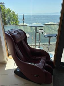 a massage chair on a balcony with a view of the ocean at LakeView Deluxe in Friedrichshafen