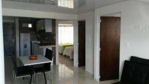 a kitchen and living room with a table and chairs at ApartaHotel Luxury in Paipa +8 photos