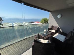 腓特烈港LakeView Deluxe的带椅子的阳台，可欣赏海景