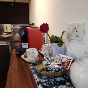 a table with a flower vase and cups on it at Appartamento Girasole in Florence