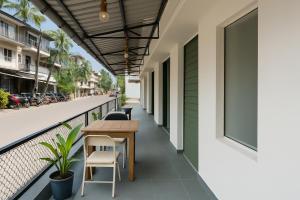 a balcony with a table and chairs on a building at Traveler Baga Beach House in Baga