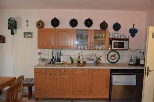 a kitchen with wooden cabinets and a counter top at Statek Vojtěšín in Vojtěšín +11 photos