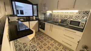 une cuisine avec un évier et un micro-ondes dans l'établissement Blue Beach Home with Terrace, à Albufeira