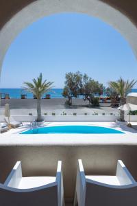 a view of a swimming pool with chairs and the beach at Casa Frati Suites & Villas in Perivolos