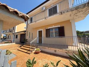 a house with a balcony and stairs in front of it at La Bombon era in Scalea