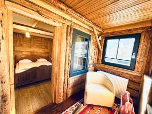 Habitación con 1 cama y 1 silla en una cabaña en Vila Eruga- Apartament 2, en Poiana Mărului 30 fotos más
