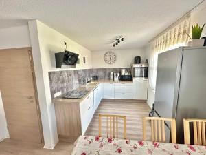 a kitchen with white cabinets and a refrigerator at FERIENHAUS AyNa, direkt an der Schweizer Grenze in Bad Säckingen