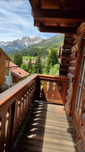 a wooden balcony with a view of a mountain at Appartamento Campitello House in Campitello di Fassa