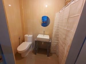 een badkamer met een wit toilet en een wastafel bij Denzel's Cosy Inn in San Juan +4 foto's