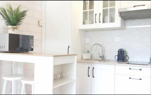 a white kitchen with white cabinets and a sink at STUDIO LE PARC plage Pereire parking WIFI in Arcachon
