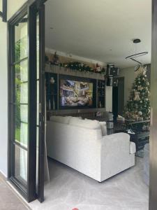 a living room with a white couch and a christmas tree at The Siburians Garden in Woloan +8 photos