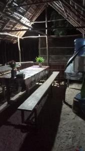 a group of wooden tables in a building with plants at Blacktive Homestay in Kri