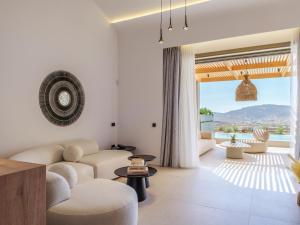 a living room with white furniture and a large window at Panormos Bay Collection Mykonos in Panormos Mykonos +90 photos