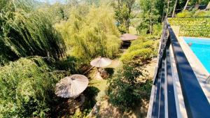 an overhead view of three umbrellas in the grass near a pool at Apartmani Drinske ploce in Bajina Bašta