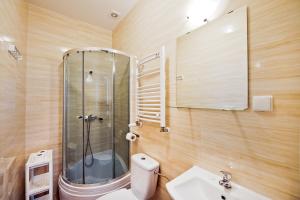 a bathroom with a shower and a toilet and a sink at Ośrodek Wypoczynkowy Jantar in Krynica Morska