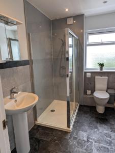 Un baño con ducha, inodoro y lavabo. en Central Pembrokeshire family home pets welcome 7 guests, en Neyland