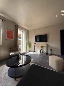 sala de estar con mesa de centro y TV en Cosy Room & SAUNA Hypercentre Dieppe, en Dieppe
