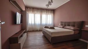 a bedroom with a large bed and a television at Bignami Home in Fiumicino