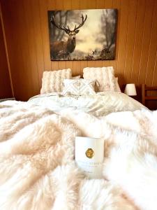 a white bed with a cup on top of it at Landhaus AUSZEIT in Borod