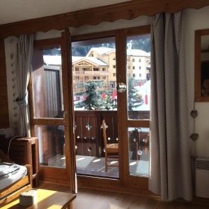 a room with a large glass door with a window at Valmorel Appartement au pied des pistes in Valmorel