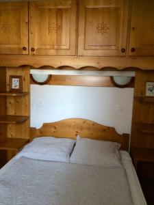 a bedroom with a bed with wooden cabinets at Valmorel Appartement au pied des pistes in Valmorel