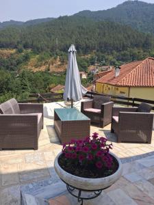 a patio with chairs and an umbrella and flowers at Casa Marciana in Geres