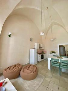 a living room with two ottomans in front of a kitchen at Casa Vacanze - Per le vie del Centro in Avetrana