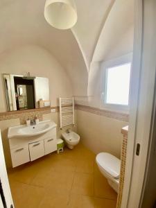 a white bathroom with a sink and a toilet at Casa Vacanze - Per le vie del Centro in Avetrana