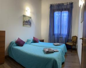 a bedroom with two beds with blue sheets and a window at TINTORETTO 4, 3 GRANDI CAMERE DA LETTO, 2 BAGNI in Venice