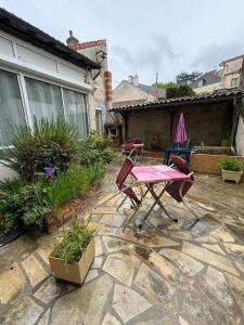 a patio with a table and chairs in a yard at Studio charmant à Néris-les-Bains - 25 m² avec terrasse in Néris-les-Bains