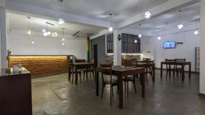 a restaurant with wooden tables and chairs in a room at Ari's Seabreeze Villas in Tangalle