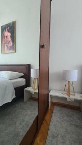 una camera da letto con un letto, due lampade e uno specchio di Vila Marija a Sarajevo