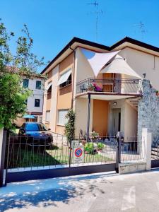 a house with a fence and a building with an umbrella at Casa Inès in Conegliano
