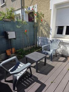 two chairs and a table on a deck at Appart T2 avec cour in Tours