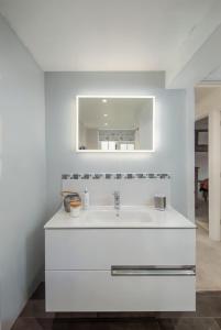 a white bathroom with a sink and a mirror at Stylish 2-bed 16th-century apartment in Petersfield town centre, in Petersfield