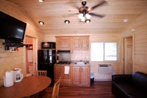 a kitchen with wooden cabinets and a ceiling fan at Soledad Canyon Cottage 5 in Ravenna
