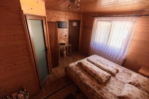 a bedroom with a bed in a wooden room at Pensiunea Casa Iulia Transalpina in Sebeş