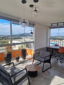 a living room with a table and chairs and windows at Studio novo com ambiente acolhedor in São João del Rei