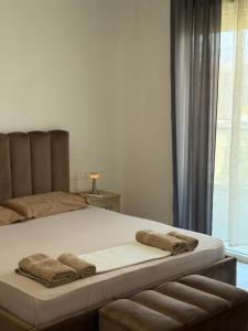 a bedroom with a bed with two towels on it at Bejart Apartment 7 in Tirana