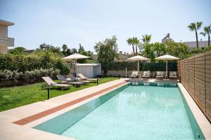 a swimming pool with chairs and umbrellas in a yard at Villa Thimi - Luxury Family Villa - Private Pool in Korakiaí