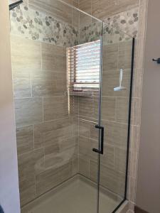 a shower with a glass door in a bathroom at Cody WY Yellowstone Luxury Mountain Retreat  +33 photos
