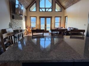 a large living room with tables and chairs and windows at Cody WY Yellowstone Luxury Mountain Retreat 