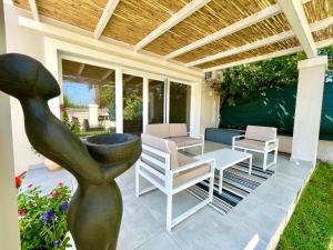 (( Litherés ))Berro's Beach House的一个带桌椅的庭院和一个喷泉