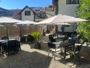 a patio with tables and chairs and umbrellas at Cetățuia - Ultra Central Râșnov Stay & Parking free in Râşnov