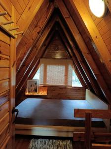a bedroom in a wooden attic with a window at Izdebno 68 in Izdebno