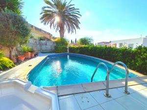 a swimming pool in a yard with a palm tree at Pink Villa in Peyia +13 photos
