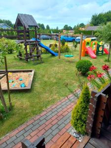 a park with a playground with a slide and swings at Domki Monte Kristo in Dąbki