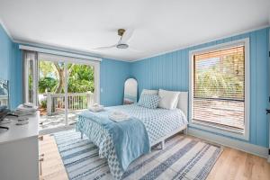 a blue bedroom with a bed and a window at Coastal Comfort at 101 Sea Otter - Fripp Island Retreat in Fripp Island +67 photos