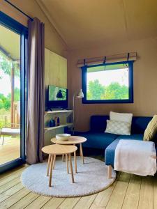a living room with a blue couch and a table at Veluwse boerderij beleving - Hoeve Meijer in Harskamp