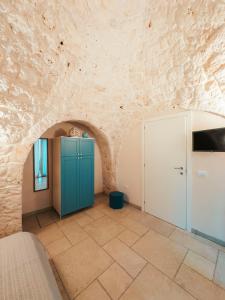 Una habitación con un armario azul y una pared de piedra. en Da Memela Trulli e Lamie per vacanze da sogno in Puglia, en Martina Franca